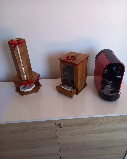 Zona de apoio com máquina de café, guardanapos e caixa de chás, para quem espera